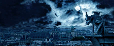 Gargoyle of Notre Dame de Paris on Halloween, France. Fantasy panoramic view of creepy Paris, skyline at gothic night. Dark haunted city with full moon. Banner with scary scene and horror background.の写真素材
