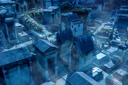 Cemetery on Halloween, scary graveyard with mystic fog at creepy night. Graves in dark misty town. Haunted spooky place with crypts and tombstones. Halloween, mystery, horror, tomb and dead concept.の写真素材