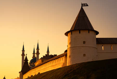 Kazan Kremlin at sunset, Tatarstan, Russia. It is the top tourist attraction of Kazan. Sunny view of white fortress wall and towers in summer evening. Scenery of historical landmark in Kazan city center.の写真素材