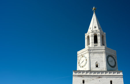 Kazan Kremlin clocktower on blue sky background, Tatarstan, Russia. Scenery of old white Spasskaya...