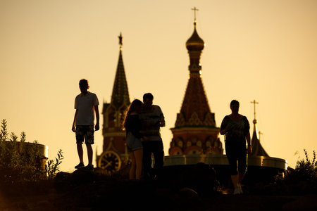 People walk Zaryadye Park in central Moscow at sunset, Russia. This place is a tourist attraction of Moscow. Towers of St Basil's Cathedral and Moscow Kremlin in background.の写真素材