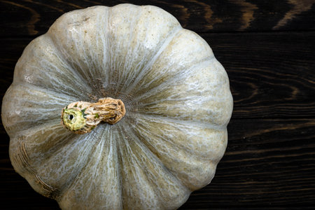 Pumpkin on dark wood background for Halloween theme, top view. Texture of whole white pumpkin, ripe vegetable. Hallowen, thanksgiving, food, squash and autumn concept.の写真素材