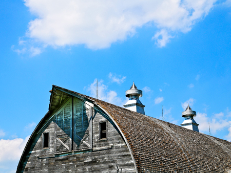Roof and cupolas of an old abandoned barn on an empty farm in northern Minnesota.の写真素材