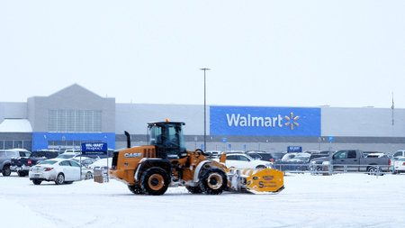 BEMIDJI, MN - DEC 27, 2018: Snow removal machine clearing Walmart parking lot during storm.