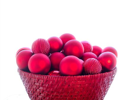 Close-up of red Christmas Bauble Balls in a red basket isolated on white background.の写真素材