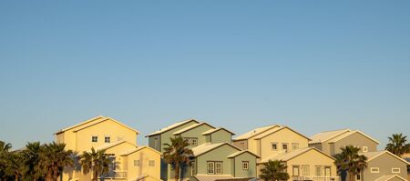 New american dream pastel colored houses side by side with clear blue sky at sunset.の写真素材