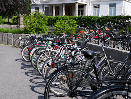 KUMLA, SWEDEN - 11 JUN 2019: Parked Bicycles in racks on urban city street near a white building.のeditorial素材