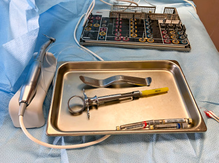 DULUTH, MN - 9 MAR 2020: Syringe, vials of local anesthetic, and a retractor on stainless steel tray. Also seen are sterile surgical instruments, including a power drill to be used by an oral surgeon.のeditorial素材