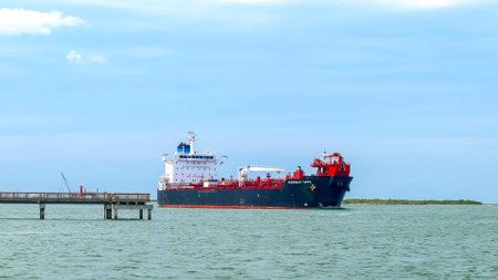 PORT ARANSAS, TX - 24 FEB 2020: The OVERSEAS TAMPA, an oil chemical tanker, sails past a pier on the ship channel between Corpus Christi, Texas and the Gulf of Mexico.のeditorial素材