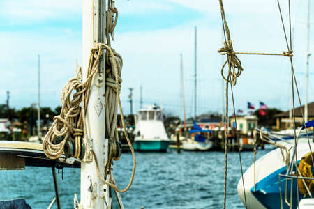 Nautical ropes ready for use on mast of sailboat close up.