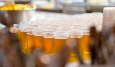 Many glasses with apple juice on the table, shallow depth of field focus.の写真素材