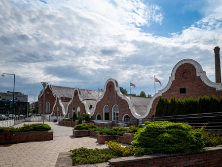 HONEFOSS, NORWAY - 7 JUN 2019: Unique brick building facade with rounded decorative borders with courtyard terrace.のeditorial素材