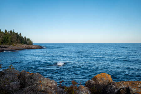 Wave from Lake Superior splashes on the rocky North Shore in Minnesota.の写真素材