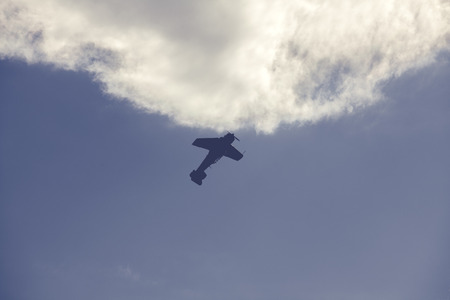 Old fighter plane on bright cloudy sky