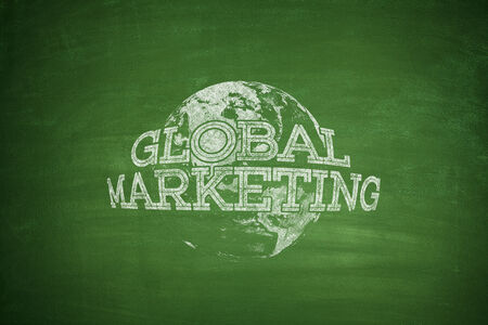 Global marketing concept on green blackboard with globeの写真素材