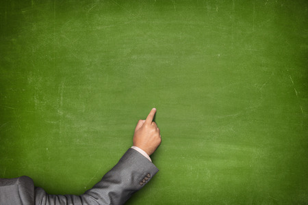 Blank green blackboard with businessman hand pointingの写真素材