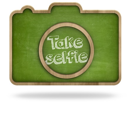 Take selfie concept on black camera shape blackboard on white backgroundの写真素材