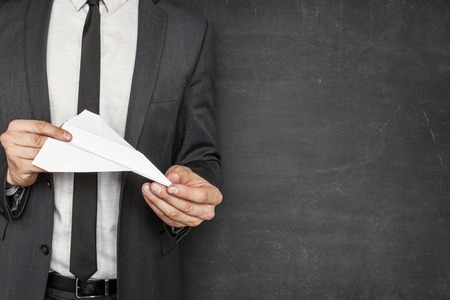 Empty blackboard with businessman on side holding paper plane in handsの写真素材
