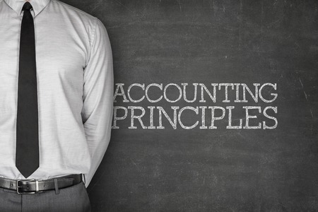 Accounting Principles on blackboard with businessman on sideの写真素材