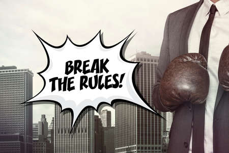 Break the rules text with businessman wearing boxing gloves on cityscape backgroundの写真素材