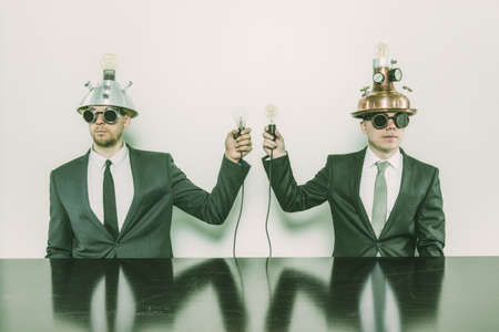 Two vintage businessman sitting at office desk with lamps