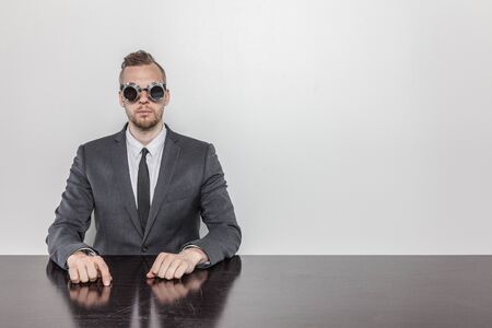 Businessman sitting at office desk wearing glassesの写真素材