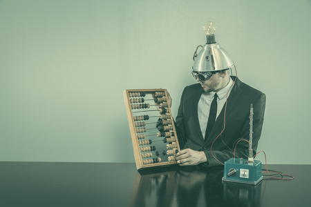 Businessman sitting at office desk with vintage gogglesの写真素材