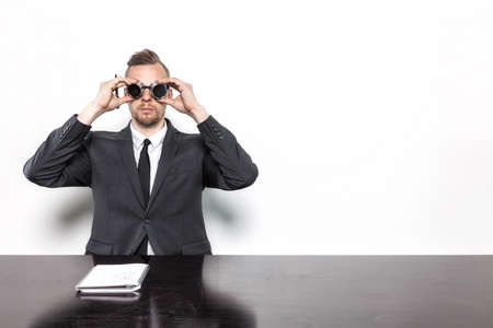 Businessman sitting at office desk with vintage gogglesの写真素材