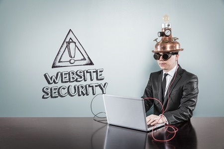 Website security text with vintage businessman using laptop at officeの写真素材