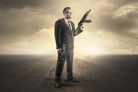 Businessman holding machine guns