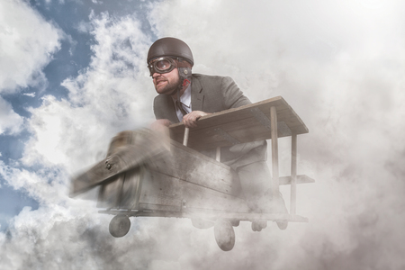 Businessman flying with a wooden toy planeの写真素材
