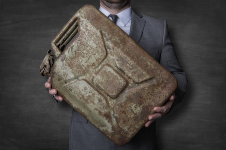 Businessman holding a oil canisterの写真素材
