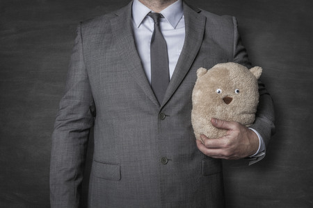Businessman in a suit holding a teddy bearの写真素材