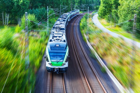 Railroad travel and railway tourism transportation industrial concept  scenic summer view of modern high speed passenger commuter train on tracks with motion blur effectの写真素材