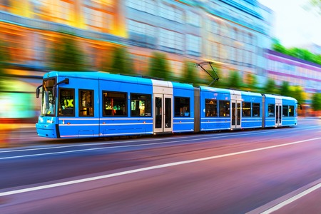 Creative abstract city transportation and business travel technology industrial concept: blue modern tram on urban city street with motion blur effect in Stockholm, Swedenの写真素材