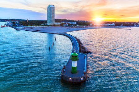 Scenic summer sunset with Baltic sea beach resort and lighthouse pier in Travemunde, Germanyの写真素材