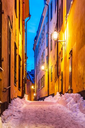 Evening winter scenery of snowy narrow street in Old Town (Gamla Stan) in Stockholm, Swedenの写真素材