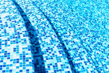 Creative abstract summer holidays, vacations and recreational activity concept background: macro view of blue tiled stone steps in swimming pool water spa resortの写真素材