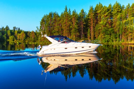 Scenic summer view of recreational yacht sailing by the lake water landscape among islands with deep forests in Finlandの写真素材
