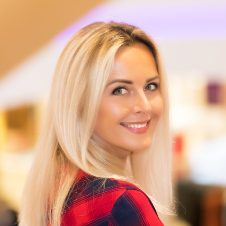 Portrait of young attractive smiling woman with long blonde hair in the fashion storeの写真素材