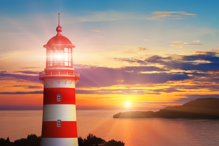 Scenic summer view of the lighthouse light and beautiful romantic sunset at the sea or ocean coastの写真素材