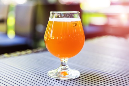 Creative abstract macro view of the glass of light beer on the table outdoors with selective focus effectの写真素材