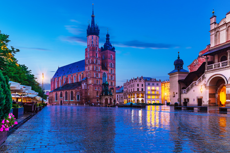Scenic summer night view of the Market Square architecture and Saint Mary Basilica Cathedral church tower in the Old Town of Krakow, Polandの写真素材