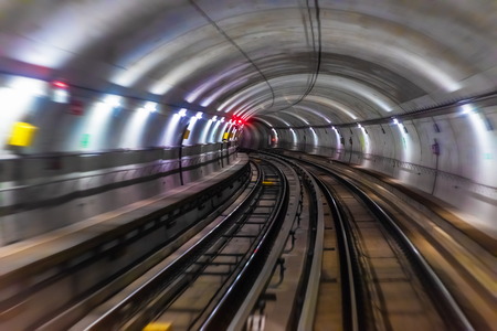 Riding the train in subway metro underground tube tunnel illuminated railroad track with motion blur effectの写真素材