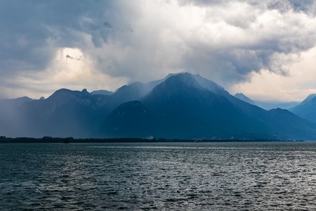 Bad cloudy overcast dramatic weather - storm, wind and rain on Geneva lake, Alps Moutains, Switzerlandの写真素材