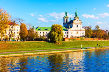 Scenic autumn view of ancient Christian Church at the Vistula river embankment in the Old Town of Krakow, Polandの写真素材