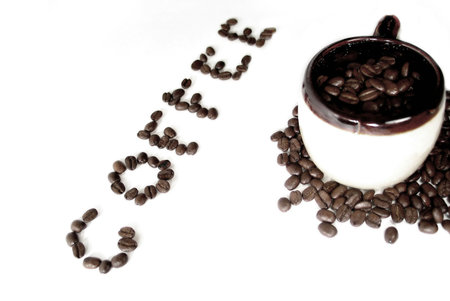  A mug filled with coffee beans, the word "coffee" spelled out in beans next to it.の写真素材