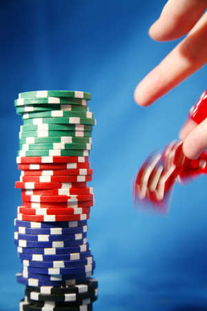 A stack of poker playing chips and a rolling die