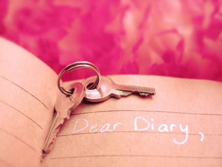 keys atop a diary with pink backgroundの写真素材