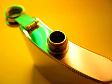 Stainless steel flask on a bright yellow background with a few highlights of green light. View from the top with the cover opened.の写真素材